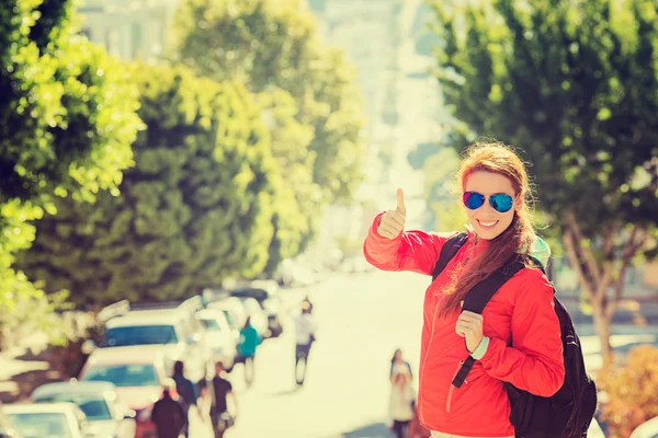 Smiling woman with sunglasses and backpack in San Francisco city on sunny day — Zdjęcie stockowe