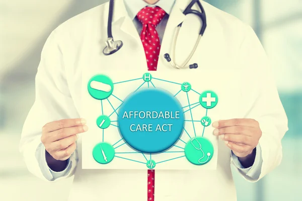 Doctor hands holding white card sign with affordable care act text message — Stock fotografie
