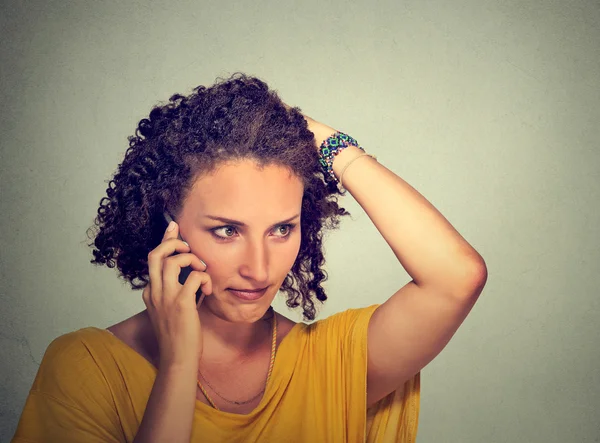 Unhappy young woman talking on mobile phone looking down stressed — Stock Photo, Image