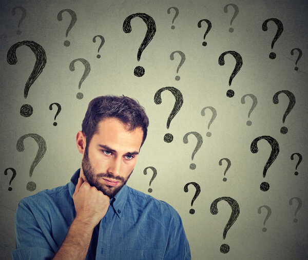 Беспокойный грустный человек имеет много вопросов глядя вниз
