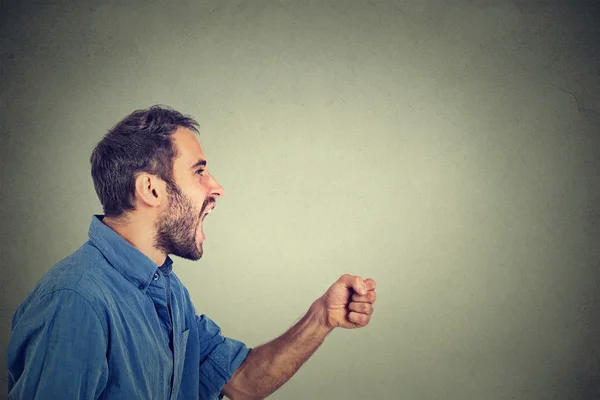 Ngry jovem gritando com punho no ar — Fotografia de Stock