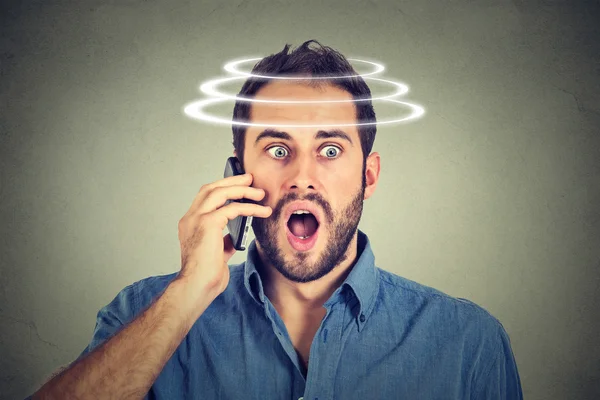 Head is spinning vertigo dizziness. Portrait shocked man talking on mobile phone. — Stock Photo, Image