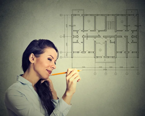 Happy young woman drawing new house floor plan with pencil — Stock Photo, Image