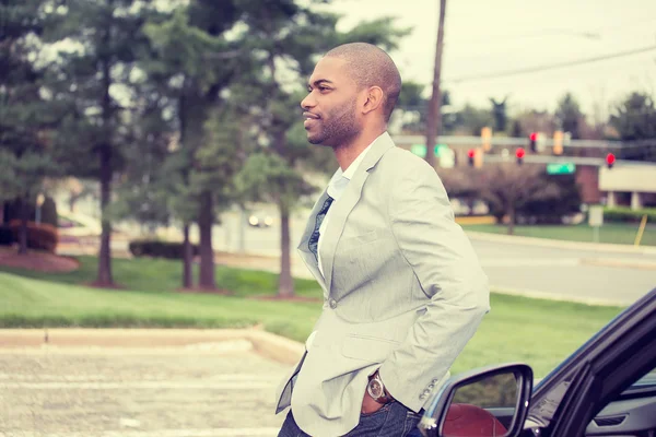 Young man standing by his new car — Stock Photo, Image