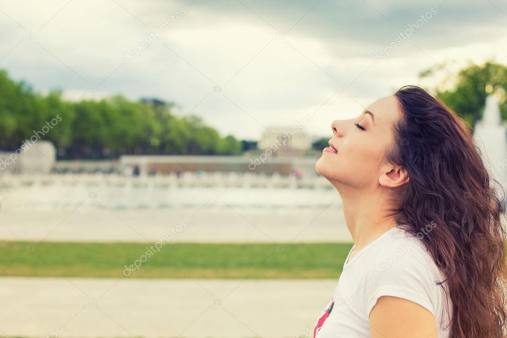 woman smiling looking up to blue sky, celebrating enjoying freedom
