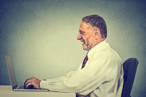 Feliz sorrindo homem digitando em seu computador portátil — Fotografia de Stock