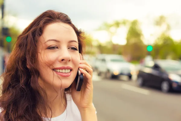 Happy young lady talking on mobile phone walking on a street — Φωτογραφία Αρχείου
