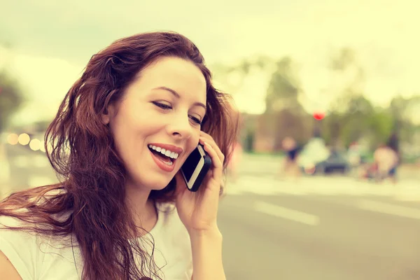 Happy young lady talking on mobile phone walking on a street — Stock fotografie