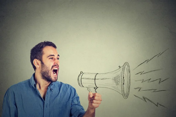 Jovem irritado segurando gritando em megafone — Fotografia de Stock