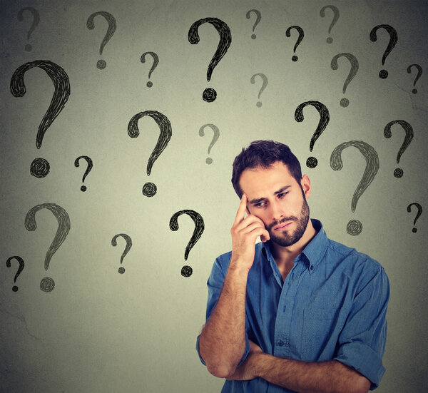 Молодой бизнесмен интересуется, глядя вниз имеет много вопросов
