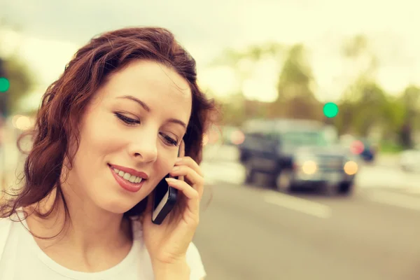 Porträtt av en ung kvinna som talar i mobiltelefon utomhus — Stockfoto