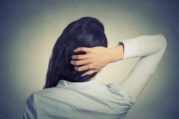 Closeup woman scratching head, back view, thinking, making decision — Stock Photo, Image