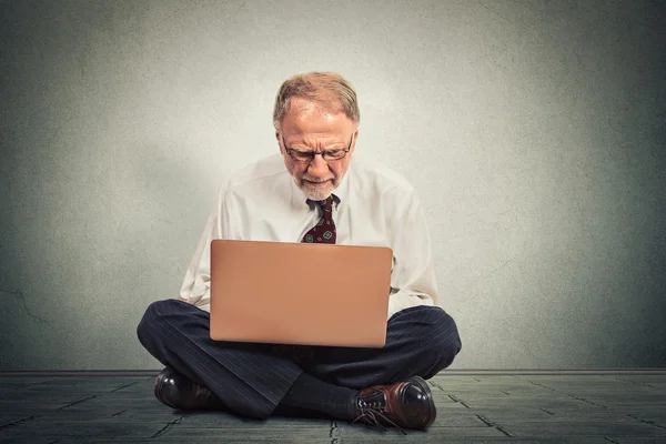 Hombre de negocios pensando y sentado en el suelo trabajando en la computadora — Foto de Stock