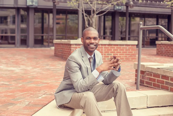 Successful happy young business man sitting outside corporate office — Stock Photo, Image