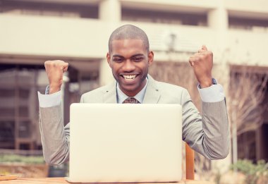 dizüstü bilgisayar ile portre mutlu başarılı genç adam başarı kutluyor 