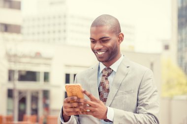 Akıllı telefon açık havada kullanan genç mutlu gülümseyen kentsel profesyonel adam 