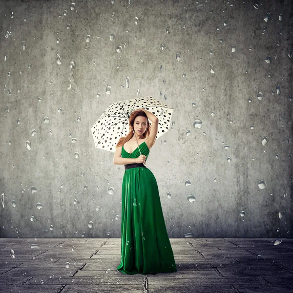 Frau mit Regenschirm auf grauem Wandhintergrund — Stockfoto