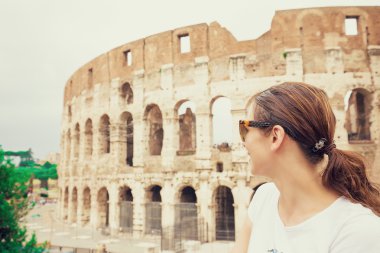 Happy young woman in front of colosseum in rome, Italy