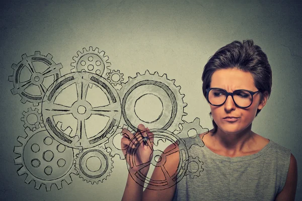 Getriebe und Ideen Kreativität Konzept. Frau mit Brille zeichnet Zahnräder mit Stift — Stockfoto