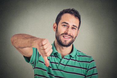 sarcastic young man showing thumbs down sign hand gesture