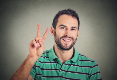 headshot young man, handsome student holding up peace victory, two sign