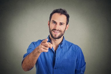Yakışıklı genç işaret parmağı sana gri duvar arka plan üzerinde izole 
