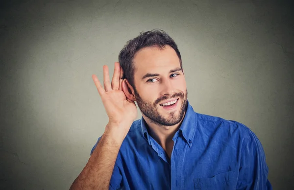 Handsome nosy business man secretly listening in on conversation, hand to ear — Stock Photo, Image