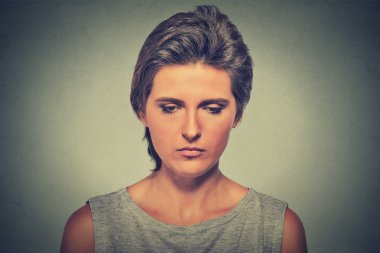 Lonely sad woman deep in thoughts looking down 