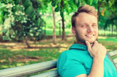 Portrait young man outdoors with park background copy space