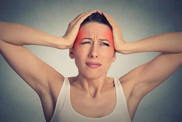Piękna kobieta cierpi na ból głowy na tle szarej ścianie tle — Zdjęcie stockowe