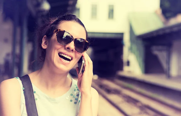 Cep telefonu açık havada üzerinde bahseden bir genç kadın portresi — Stok fotoğraf