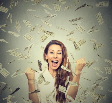 mutlu kadın pompalama yumruk kendinden geçmiş exults bir para yağmur altında başarı kutluyor