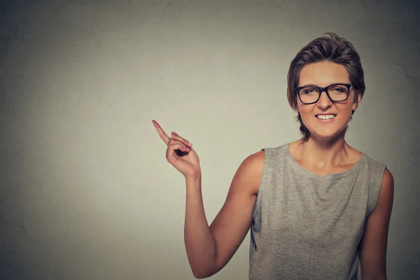 Mujer feliz en gafas apuntando con el dedo al espacio de copia en blanco —  Fotos de Stock