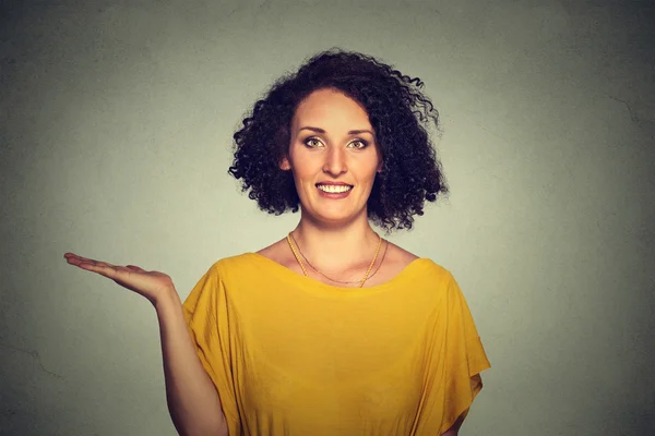 Feliz bastante seguro joven sonriente mujer gesto presentando espacio a la izquierda — Foto de Stock