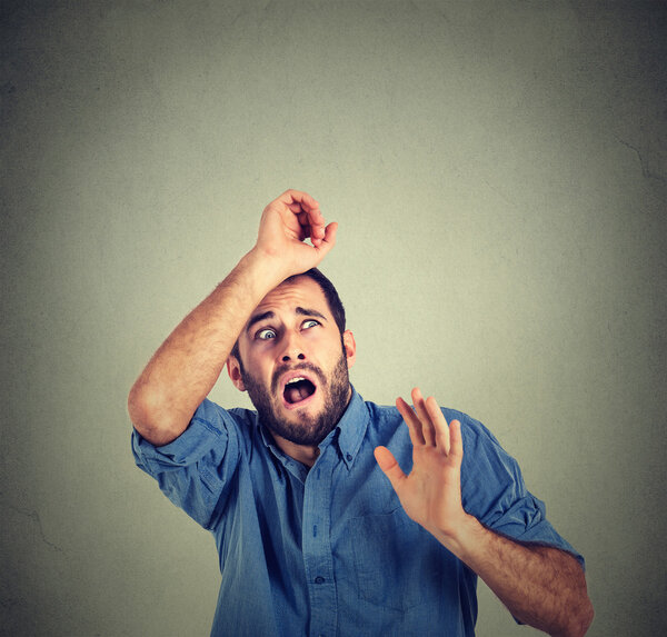 man looking shocked scared trying to protect himself from unpleasant situation