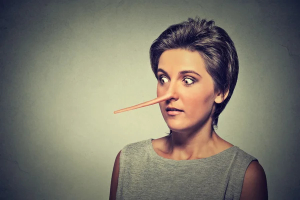 Frau mit langer Nase isoliert auf grauem Wandhintergrund. Lügenkonzept — Stockfoto