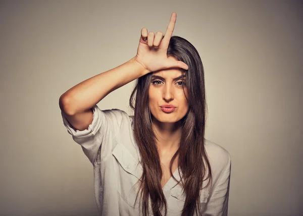 Unhappy woman giving loser sign on forehead, looking at you, disgust on face — Stock Photo, Image
