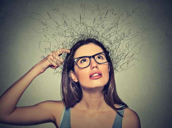 Woman scratching head, thinking with brain melting into lines question marks — Stock Photo, Image