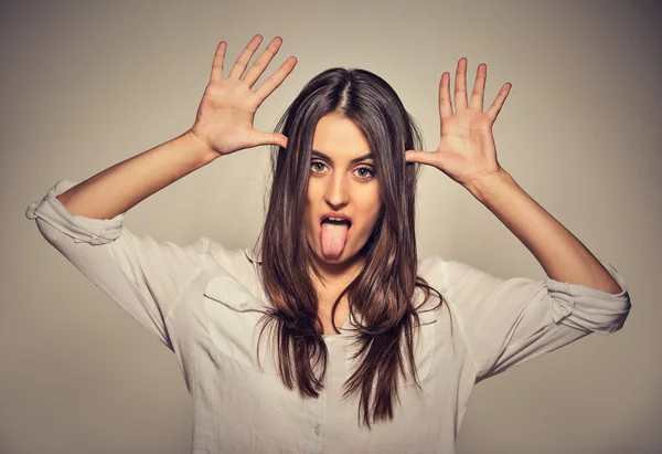 Joven mujer bonita con cara divertida burlándose de alguien sacando la lengua — Foto de Stock