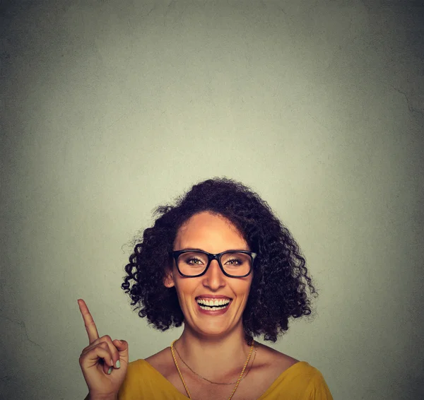 Happy woman in glasses pointing up with her finger — ストック写真