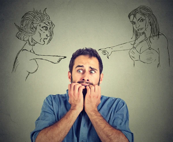 Bad evil women pointing at stressed anxious young man — Stockfoto