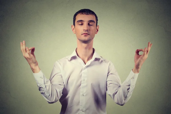 Young man meditating isolated on gray wall background — Stock Fotó