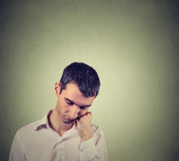 Sad, depressed, alone, disappointed man resting his head on hand looking down — Φωτογραφία Αρχείου