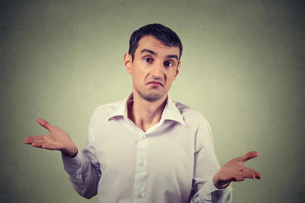 Young upset man shrugging shoulders who cares so what I don't know gesture — Stock Photo, Image