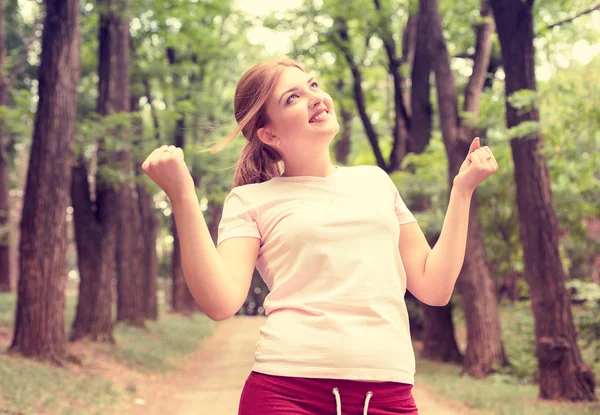 ワークアウト後に腕を上げるフィットネス女性。公園の背景に幸せな女性アスリート. — ストック写真
