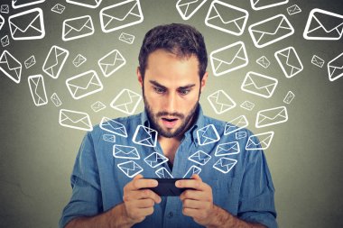 Shocked man busy sending messages emails from smart phone email icons flying of mobile phone clipart