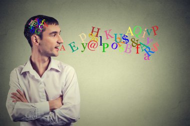 Side view portrait man talking with alphabet letters in his head coming out of open mouth 