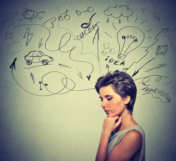 Worried young woman thinking dreaming has many ideas looking down — Stockfoto