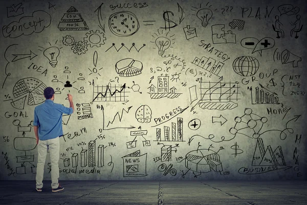 Hombre de negocios joven empresario escribir algunos nuevos cálculos de proyectos en la pared gris — Foto de Stock