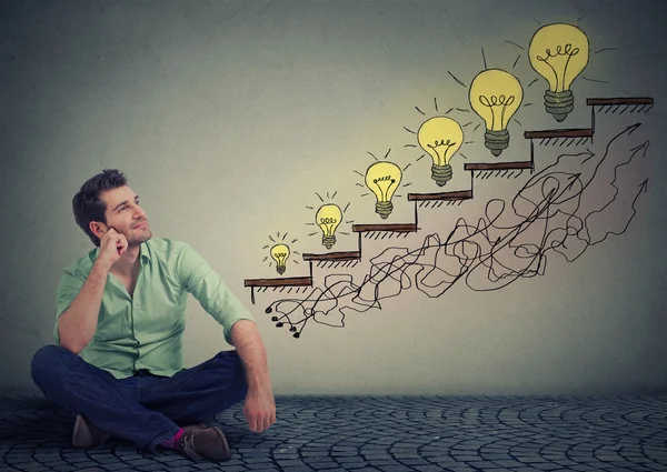 Happy man sitting on a floor in his office dreaming of business education success — Stock Photo, Image